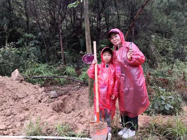 植树节来临之际，游客在观音山冒雨植树热情高